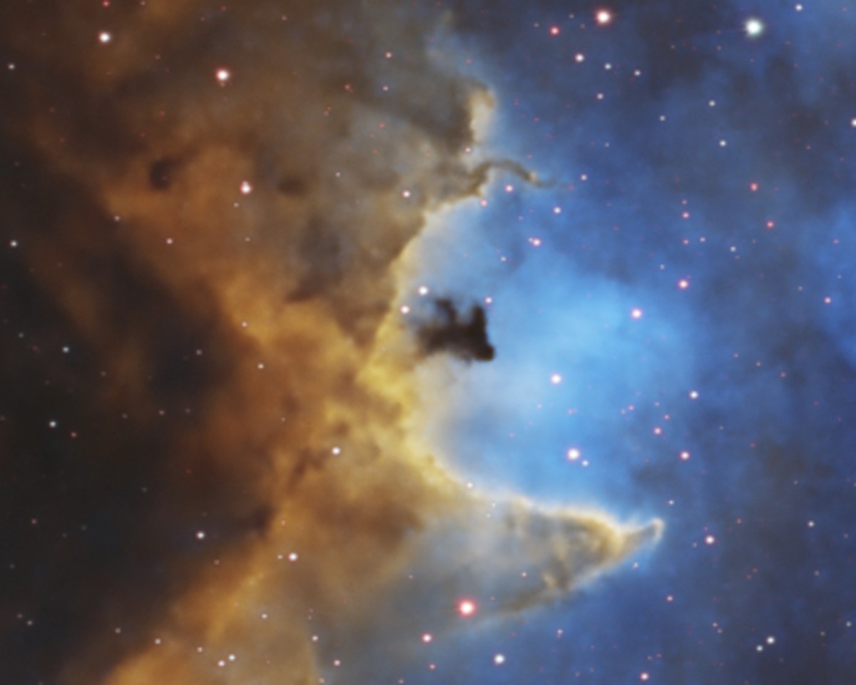 Un petit globule de poussière sombre dressé au bord de la cavité brillante, dont la silhouette évoque un petit bonhomme.